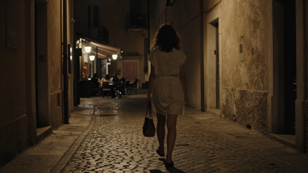A woman walking alone down a quiet Ajaccio alley at night, illuminated by a single streetlamp.